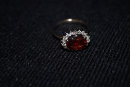 A ladies diamond and garnet ring, stamped "750"