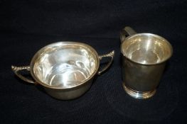 A silver mug and dish