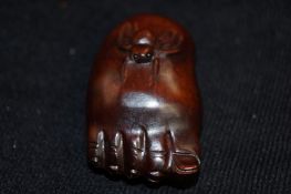 A carved Netsuke of a foot and a spider