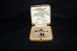 An Edwardian Gold Amethyst and half pearl oval cluster brooch and a similar bar brooch in a case