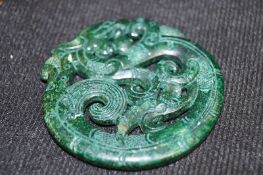 A carved oriental jade pendant of a dragon