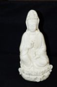 A Chinese Blanc De Chine figure of Guanyin, decorated with Lotus Flowers to the base. 27cm height,