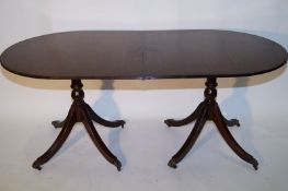 A reproduction mahogany dining room table
