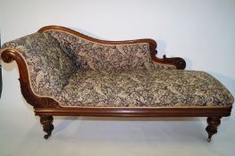 An Edwardian chaise lounge upholstered decorated with floral fabric on bulbous feet