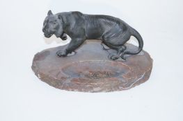 A metal model of a tiger with a marble ashtray