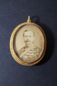 A gold coloured pendant of a gentleman in military dress