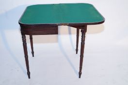 A mahogany card table with a felt interior and turned legs