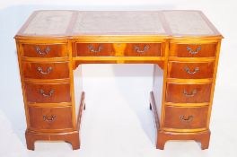 A yew wood pedestal desk with a leather insert