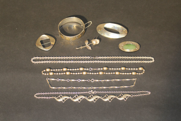 A collection of various silver jewellery to include a Georg Jensen brooch, three further brooches,