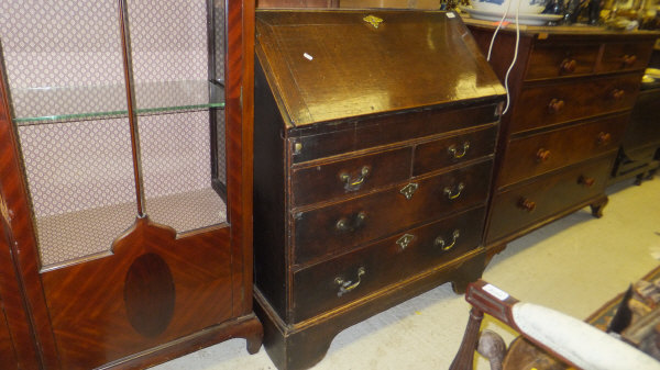 A George III oak bureau, the fitted interior with well