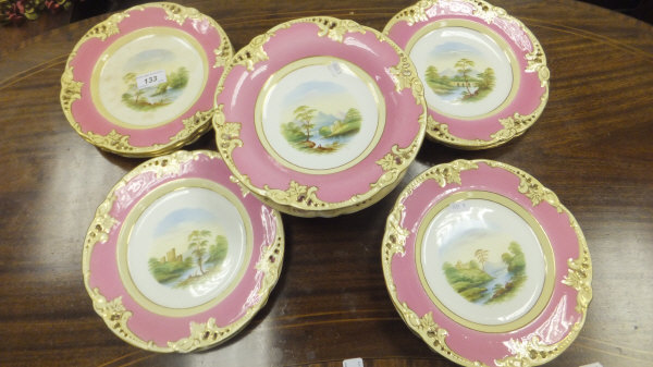 A Continental porcelain part dessert service painted with landscapes within pink and gilt