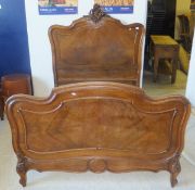 A French walnut double bedstead in the Louis XV taste, the headboard with central scroll and