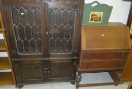 An oak bookcase cabinet in the 17th Century taste with two leaded glazed cupboard doors over two