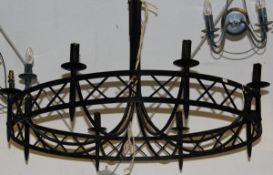 A large black painted wrought iron eight branch chandelier