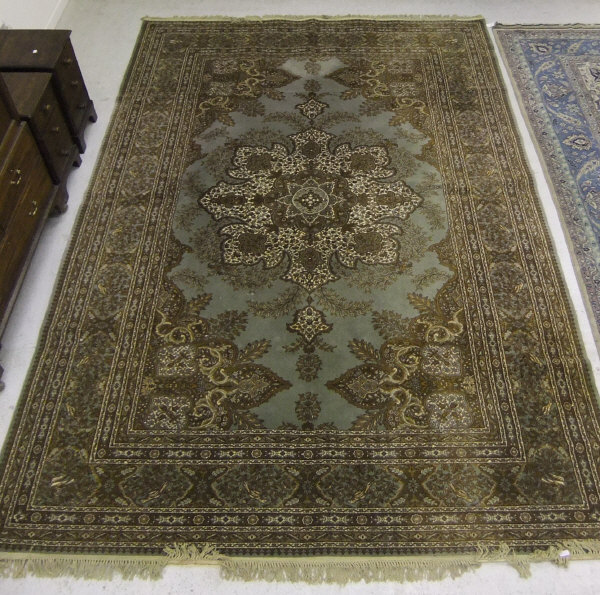 A modern Persian patterned Wilton carpet, the central panel set with floral patterned medallion on a