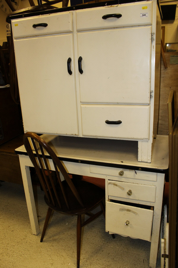 An enamelled top painted cupboard of two short drawers above two cupboard doors and a further single