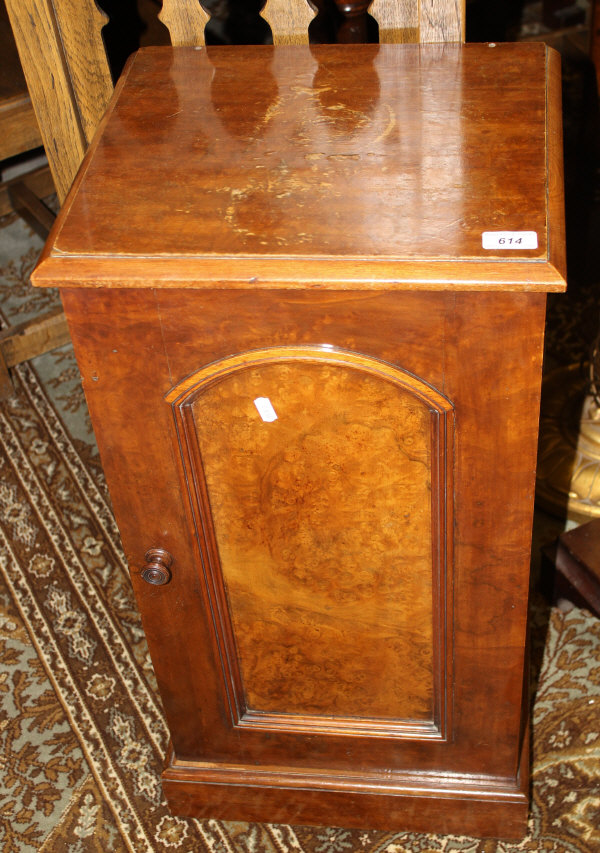 A late Victorian burr walnut pot cupboard, the plain top above an arched door on a plinth base