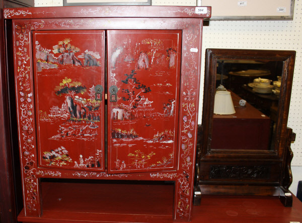 A modern painted and lacquered dwarf cupboard with two doors enclosing a shelf raised on stile