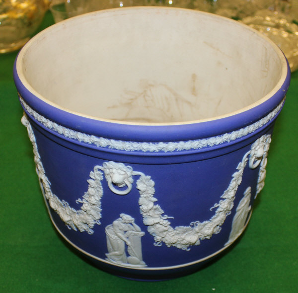 A Wedgwood blue Jasperware jardiniere decorated with grape, vine swags, Classical figures and lion