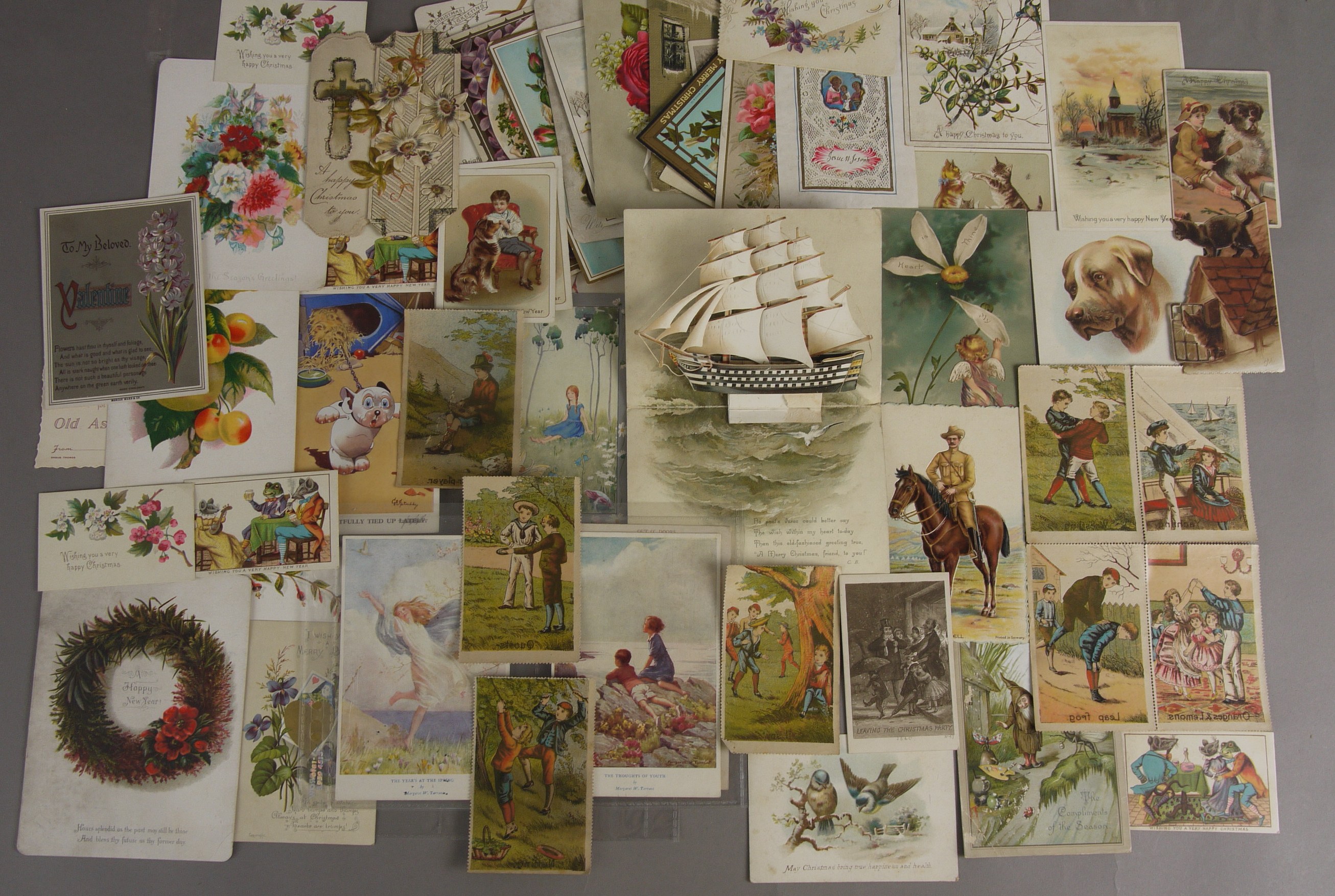 A COLLECTION OF APPROXIMATELY SIXTY EARLY 20TH CENTURY GREETINGS CARDS AND POSTCARDS, including