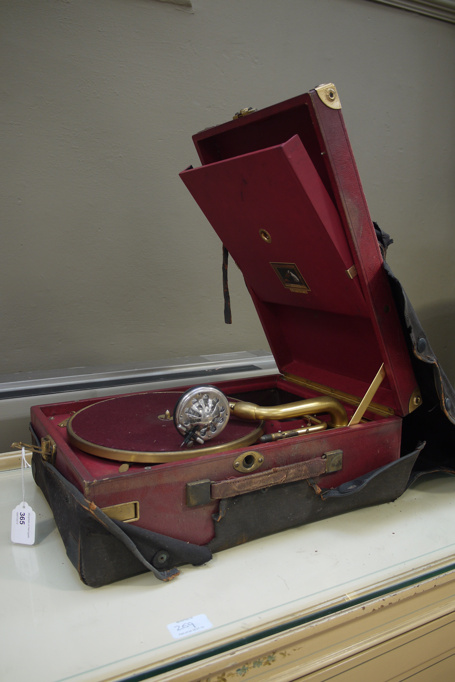 An HMV portable gramophone, the red leather-covered and gilt metal mounted case with No. 5