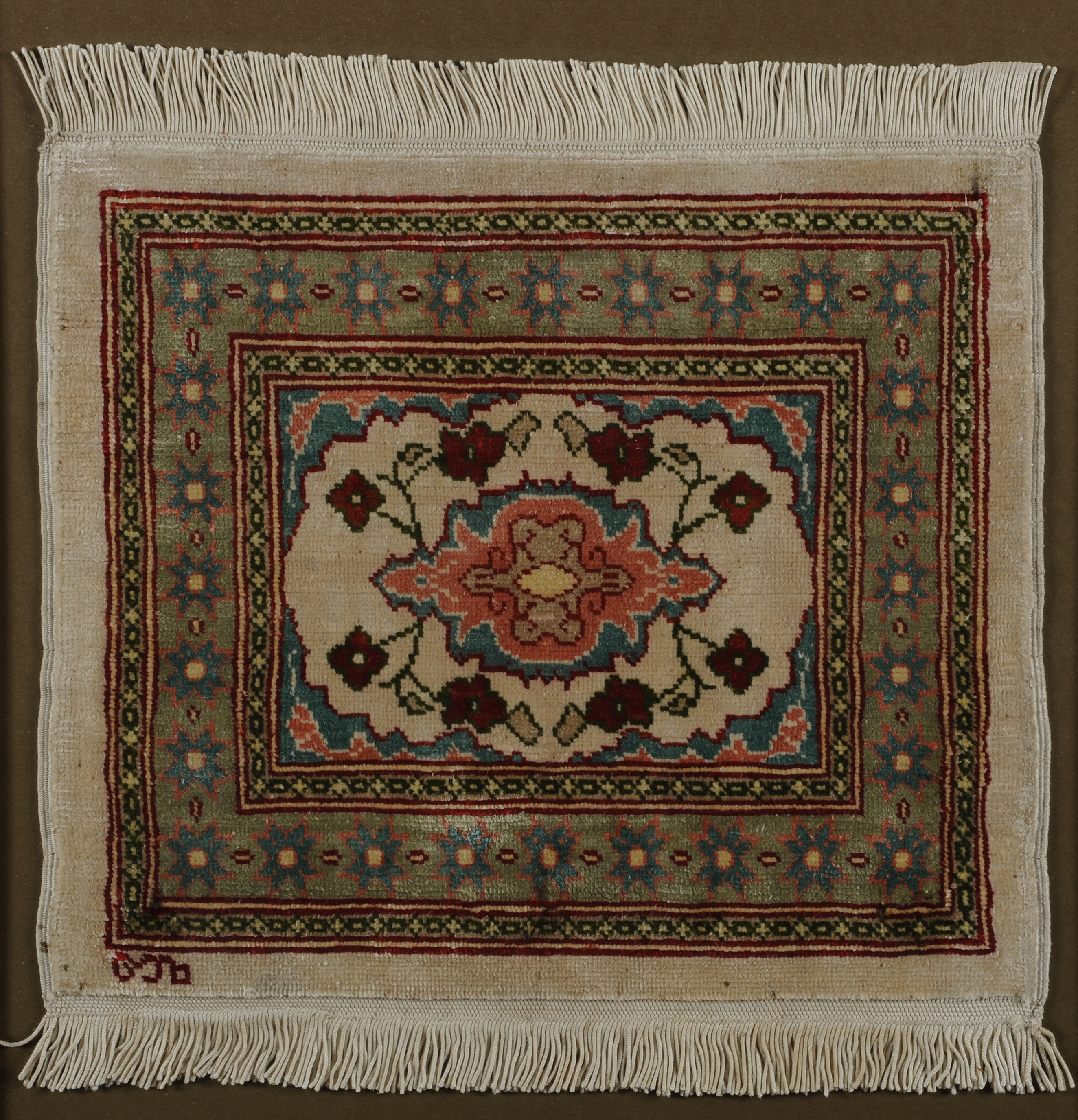 A CAUCASIAN MINIATURE SILK RUG, with a central floral medallion with corner spandrels on a cream