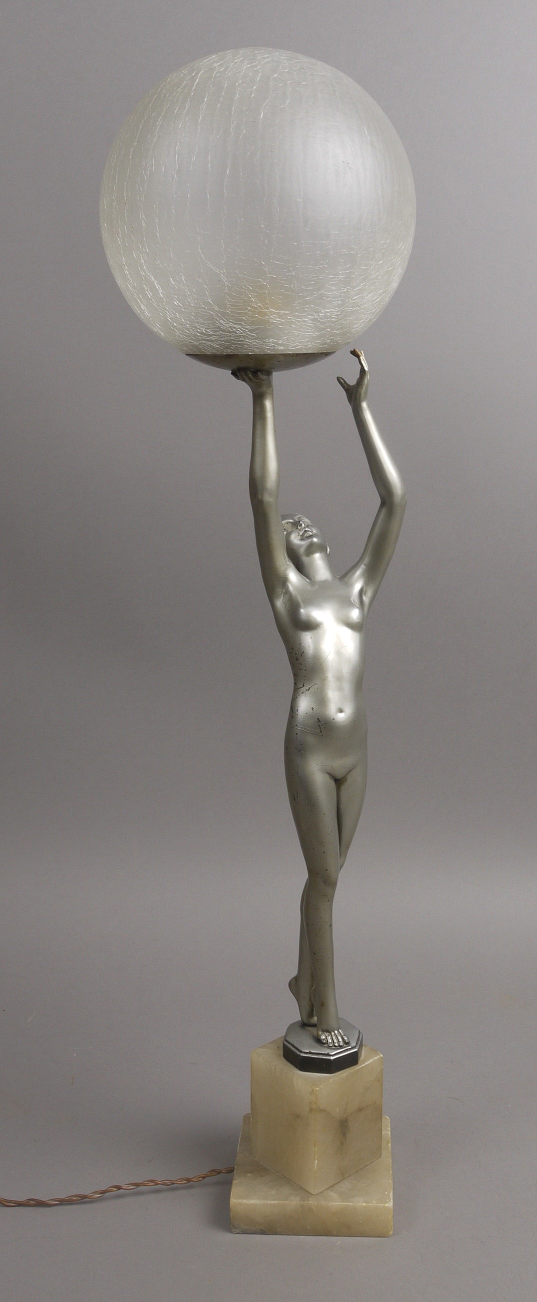 AN ART DECO TABLE LAMP, formed as a silvered bronze figure of a naked female, supporting a