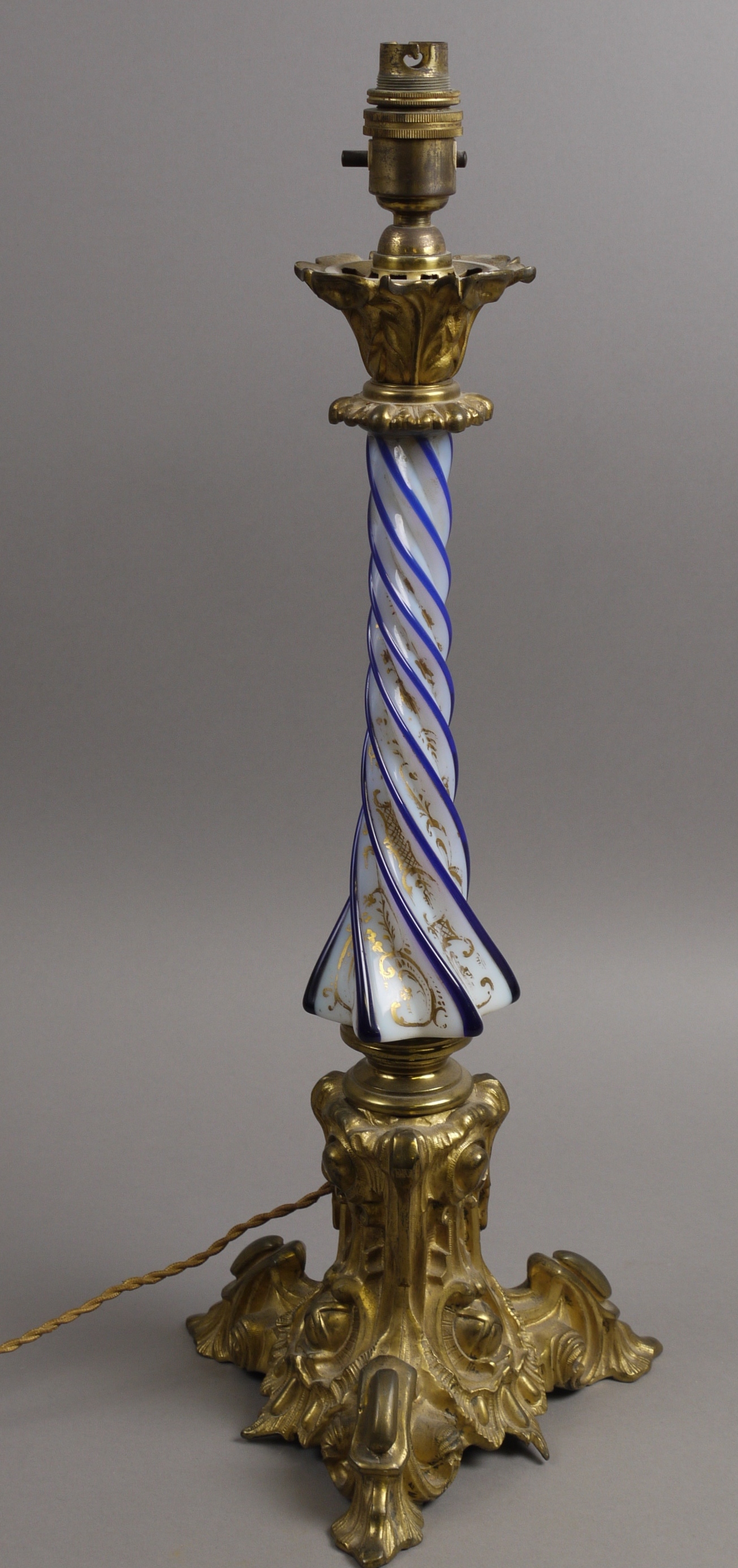 A FRENCH ORMOLU, OPAQUE AND BLUE CASED GLASS LAMP BASE, the wrythen fluted column decorated with