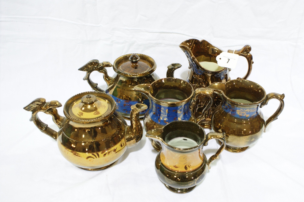 Four Copper Lustre Decorated Milk Jugs Together With Two Similar Copper Lustre Tea Pots