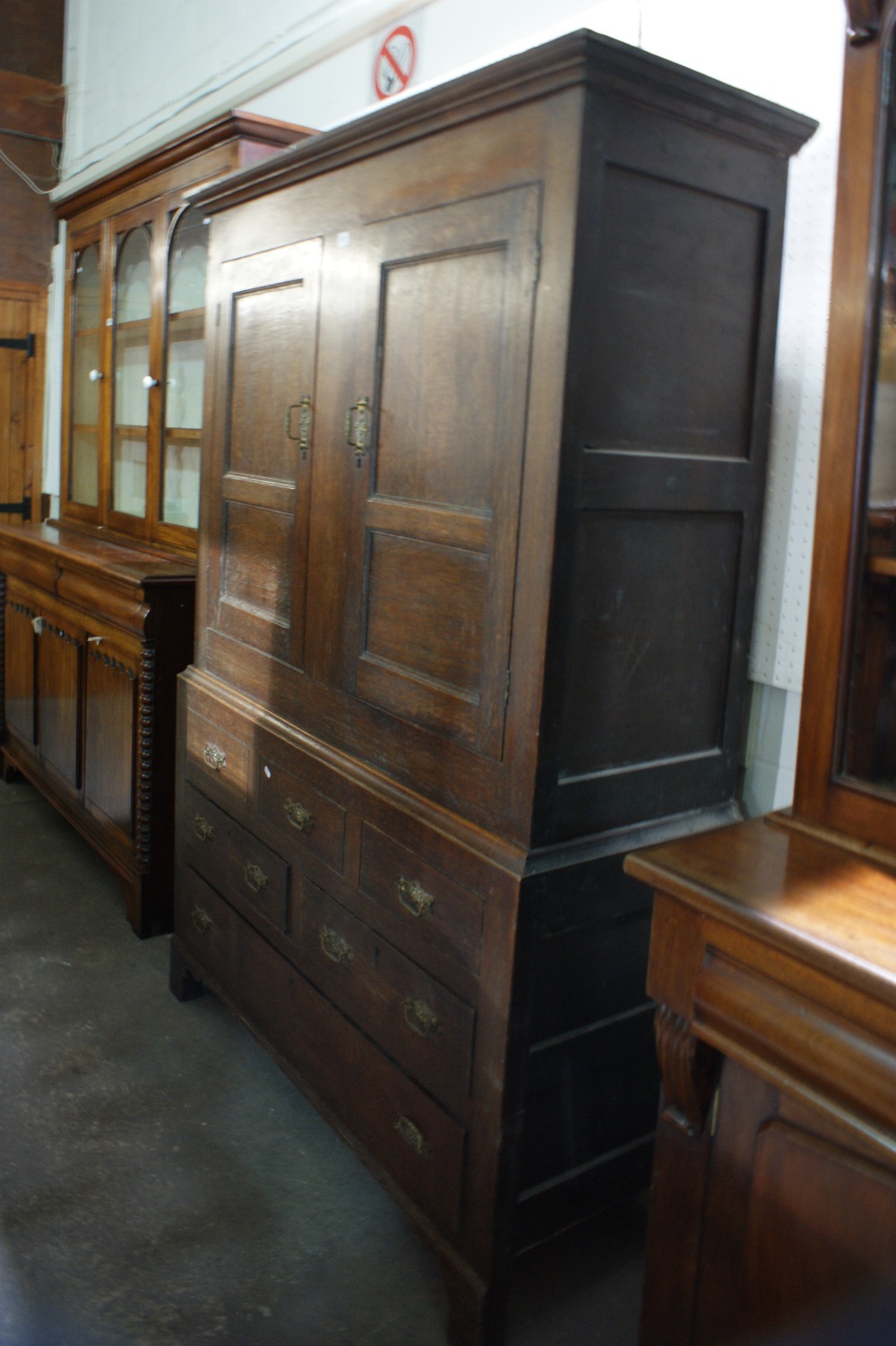 An Antique Oak Two Piece Linen Press Cupboard Having A Panelled Cupboard Door Top And A Base Of