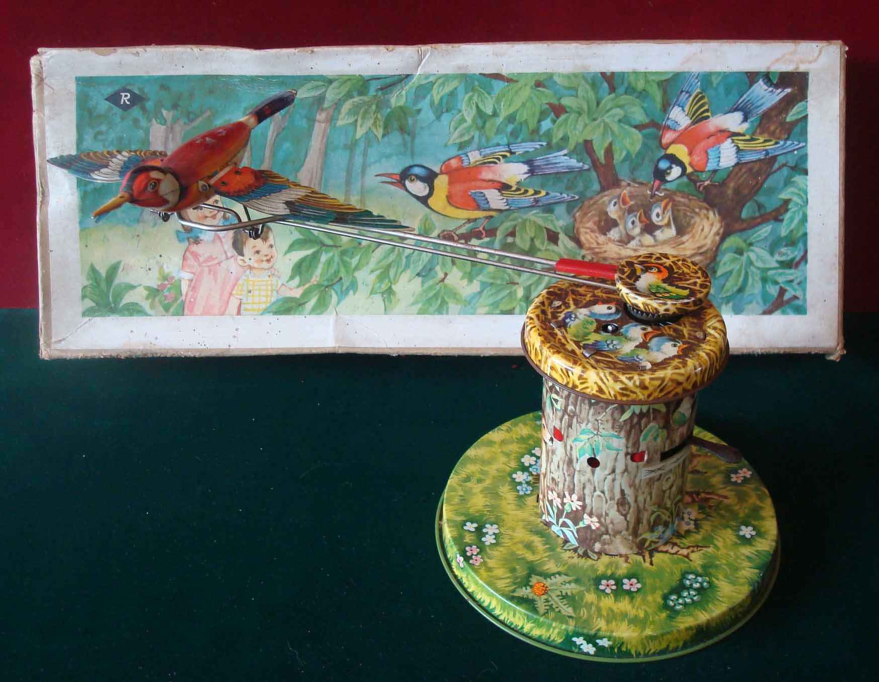 R (Western Germany) Flying Bird tinplate novelty toy: 1960s, colourfully lithographed base depicting
