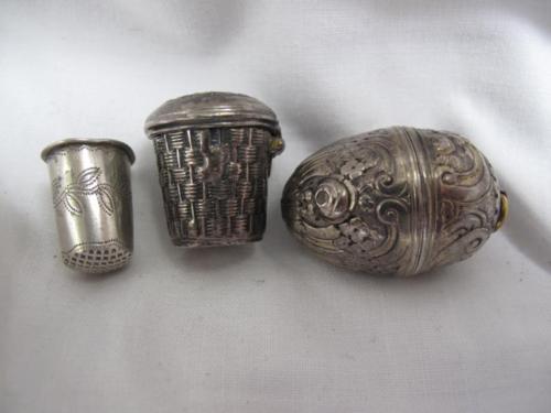 Victorian chased egg-shaped silver metal nutmeg holder, together with a basket-shaped thimble