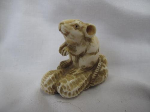 Late 19thC Japanese carved ivory netsuke in the form of a mouse sitting on three peanuts, begging.