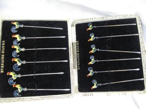 Two cased sets of six sterling silver cocktail sticks with enamel roosters to the tops.