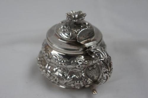 GIV silver chased mustard pot of squat baluster form with flower finial, shell thumb rest to top