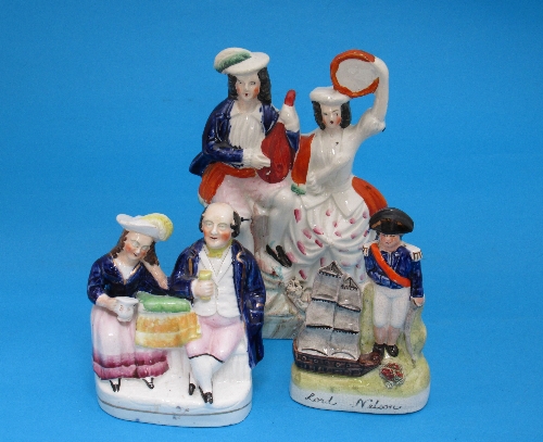 Three Staffordshire flatback figures, of Lord Nelson with ship, 15cm, a seated couple of drinkers,