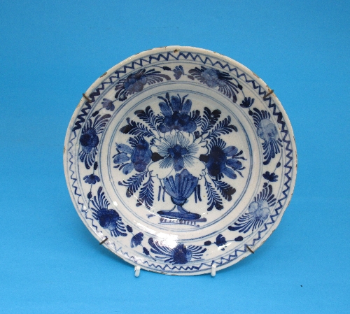 A Delft blue and white dish, with central design of flowers in a vase, 23cm.