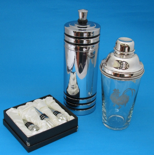 Two cocktail shakers and a boxed set of three cut glass bottle stoppers.