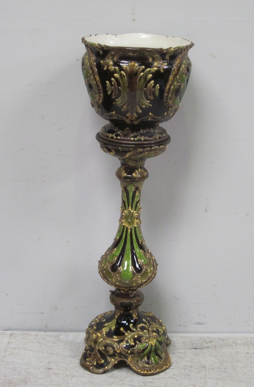 A Victorian jardiniere and stand, in green and brown glaze with scrolls and foliage, height 116cm.