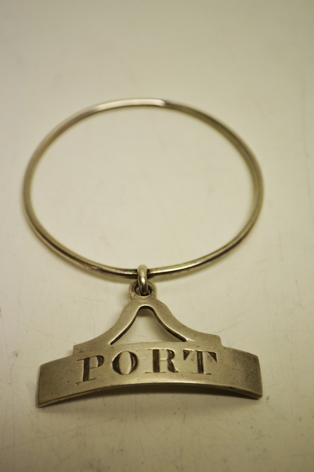A Regency silver decanter label for Port, on a ring. Maker Robert Garrard. London 1813.