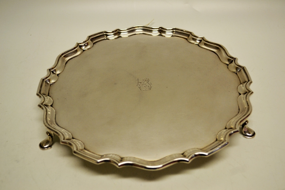 A circular silver salver, the centre engraved a crest, a raised moulded `Chippendale` pie crust