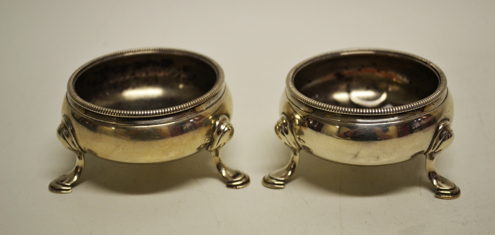 A pair of George III silver compressed circular salts, with cable borders, the legs on hoof feet,