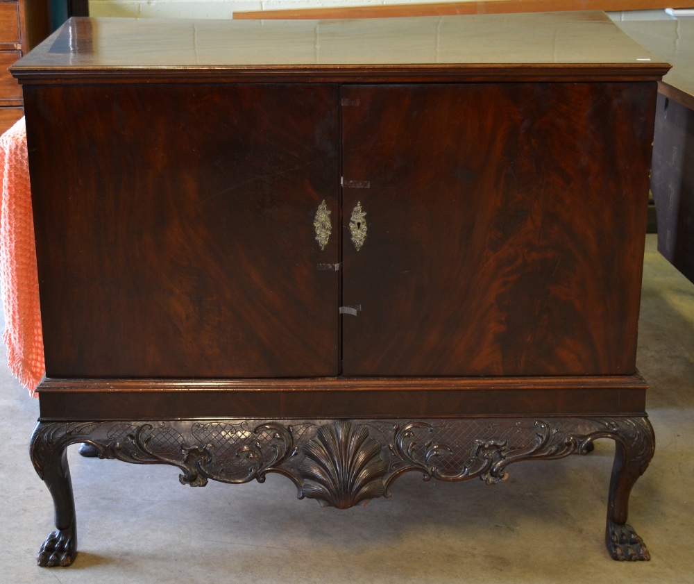 An Irish mahogany dining room linen cupboard, the pair of doors enclosing a shelf, above a foliage