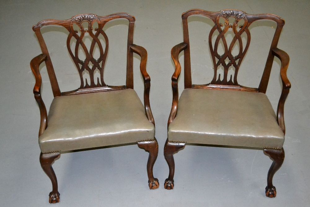 A pair of mid eighteenth century style mahogany elbow chairs, with pierced entwined splats to the