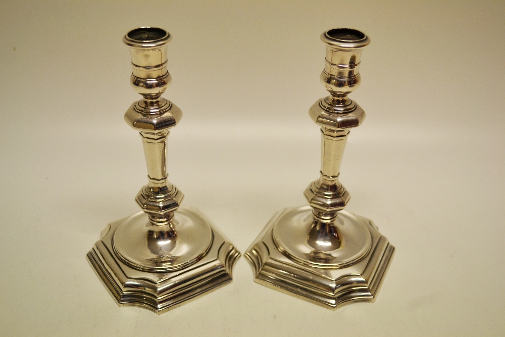 A pair of George 1st silver cast candlesticks, the baluster knopped octagonal stems with ring turned