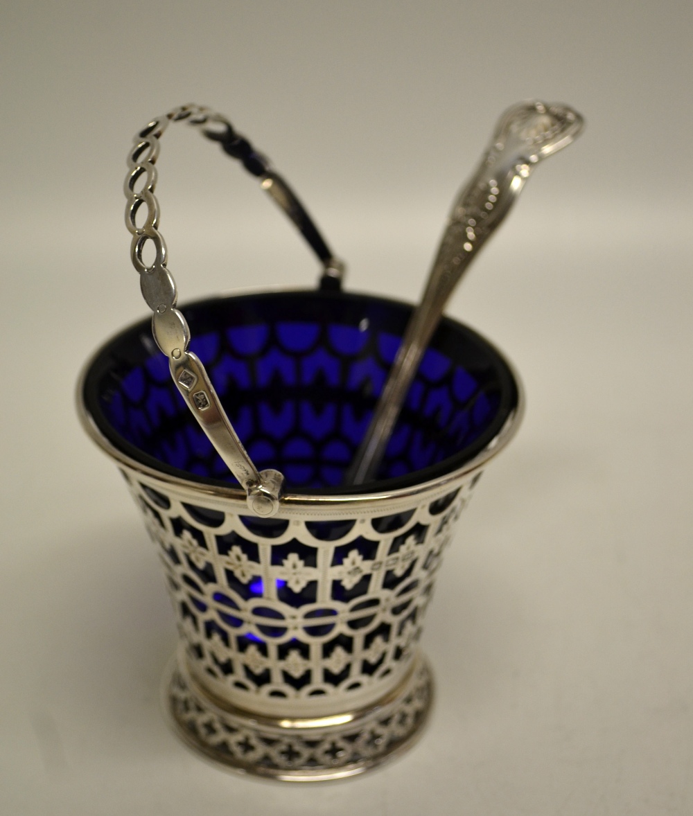 An Edwardian silver cream basket with pierced and engraved fretwork, with a pierced swing handle,