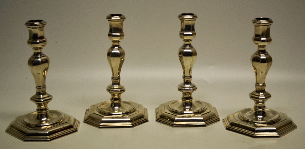 A set of four cast silver candlesticks, in George 1st style, the octagonal knopped stems with