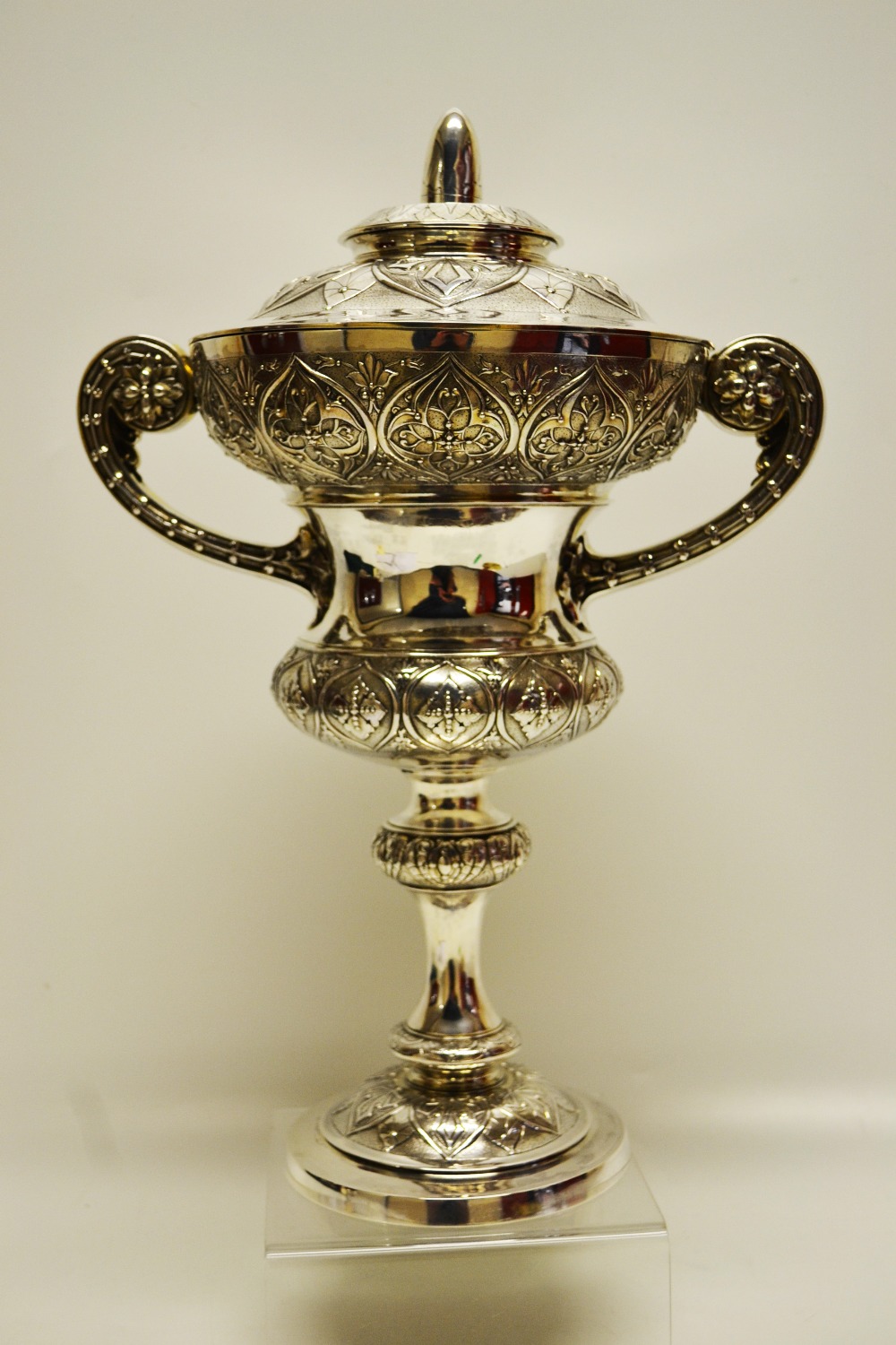 A high Victorian silver standing cup, the waisted body chased with borders of repoussé Medieval