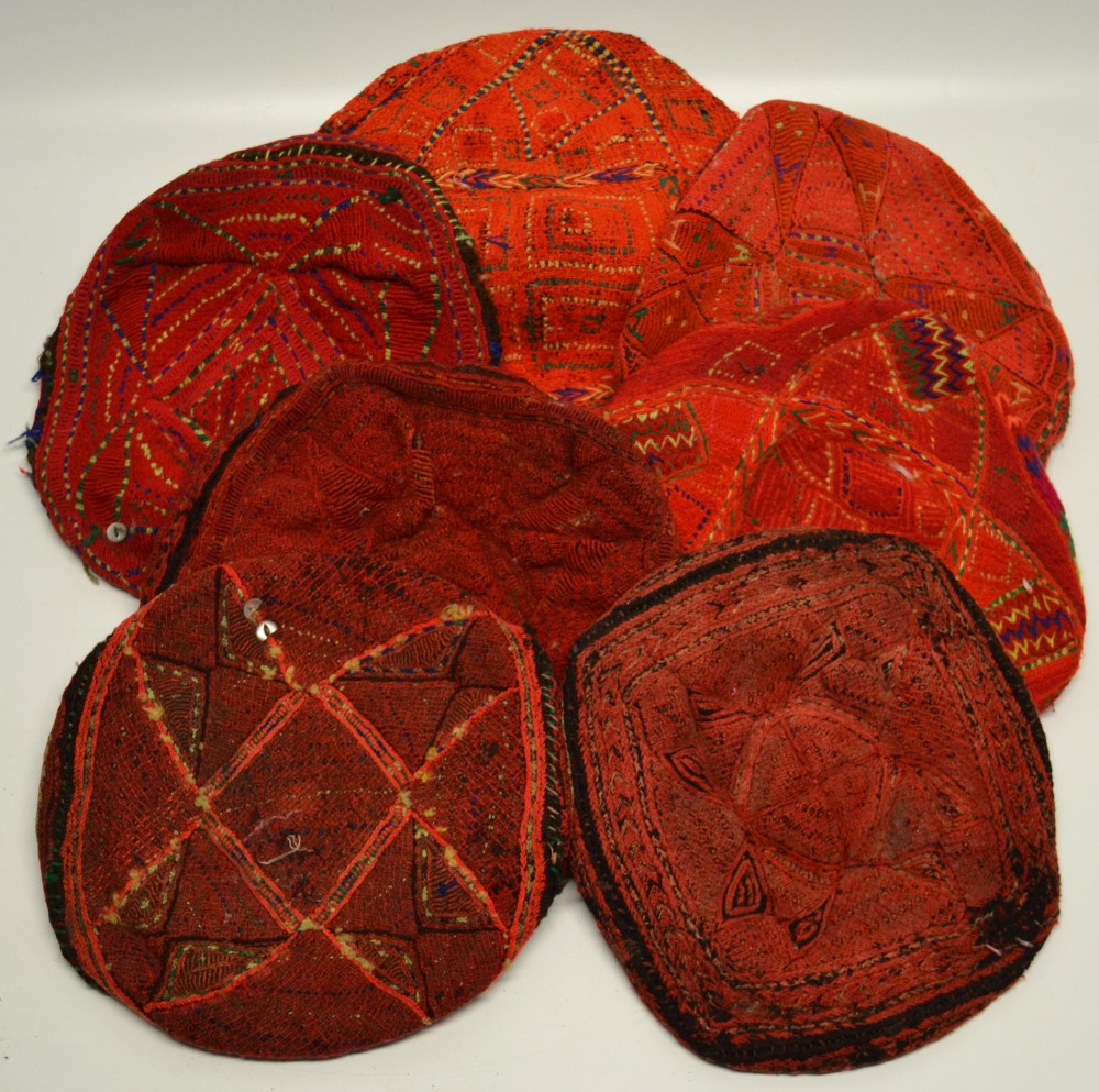 Seven Waziri men`s hats, of tam o`shanter form in red embroidered wool, Afghanistan 20th century. (