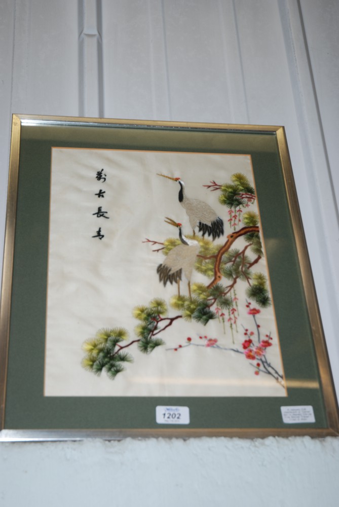 A Japanese Silk Needlework of Sacred Ibis amongst spring tree Blossom. Signed - Framed and mounted.